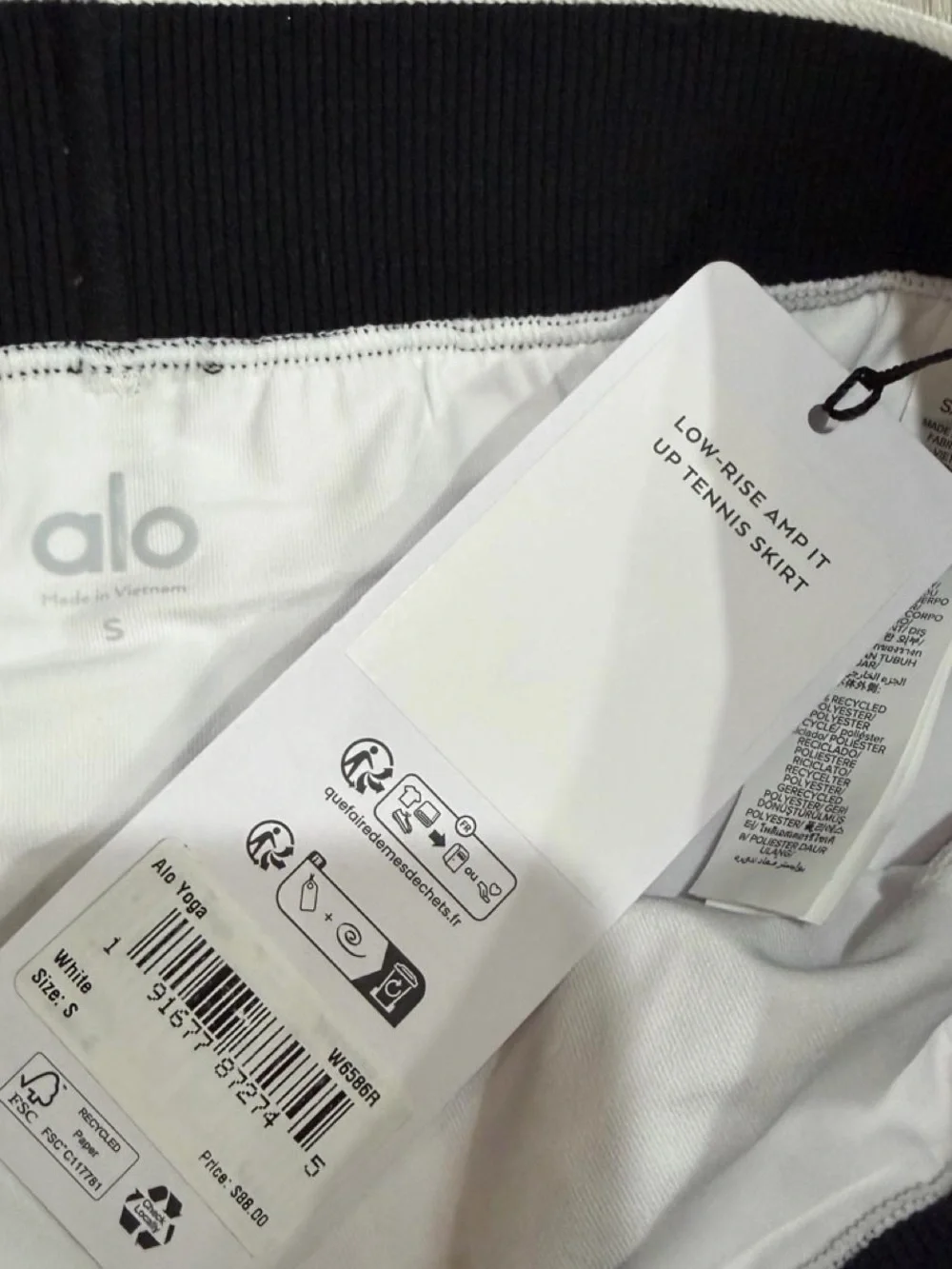alo Yoga Low Rise AMP It Up Tennis Skirt in White with Black Waistband. SIZE: S